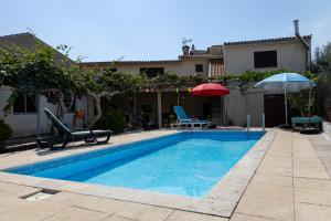 a swimming pool with two chairs and an umbrella at Edu Stay Mondego in São Pedro de Alva