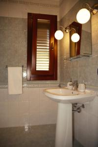 ein Badezimmer mit einem weißen Waschbecken und einem Spiegel in der Unterkunft BnB DonnaLaura in Carini