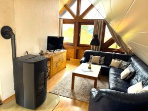a living room with a black leather couch and a tv at Bohn-Ferienwohnungen in Mosbach