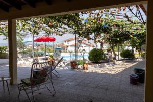 a patio with chairs and a table and a pool at Edu Stay Mondego in São Pedro de Alva