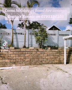 een wit gebouw met palmbomen voor een bakstenen muur bij Renves's Palace in Margate +8 foto's