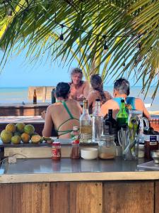 a group of people sitting at a table with alcohol at Manoush Beach in Buritaca +51 photos