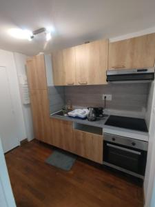 una cucina con mobili in legno e un forno a piano cottura di Studio cosy et lumineux avec climatisation a Châteauroux