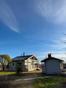 a house with a garage next to a building at Riverside cottage in Rovaniemi