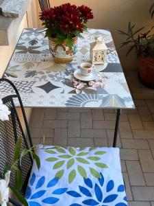 een tafel met een koffiekopje en bloemen erop bij Casa Nuara in Novara