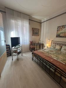 een slaapkamer met een bed, een bureau en een televisie bij Casa Nuara in Novara +73 foto's