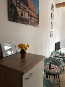 ein Zimmer mit Stühlen und einem Tisch mit einer Blumenvase in der Unterkunft Historisches Hotel Wildeshauser Bahnhof in Wildeshausen