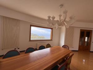 een eetkamer met een tafel, stoelen en een kroonluchter bij Luxury Villa with Pool and Garden in Ricadi