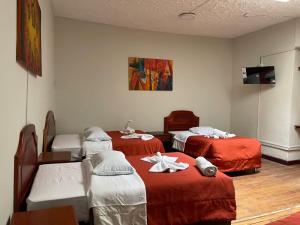 een ziekenhuiskamer met drie bedden en een tv bij Inkas Hotel Cusco in Cuzco