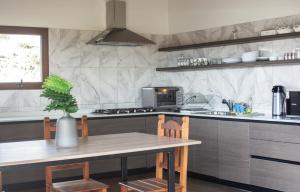 a kitchen with a wooden table and a counter top at Hostel Casa del Viajero 2 in El Calafate