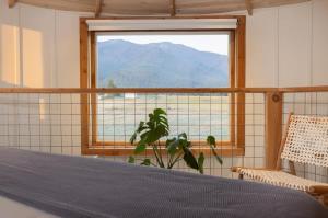 Un dormitorio con una ventana con vista a la montaña. en Clark Farm Silos - 5 Silo Mountain View Retreat, en Kalispell