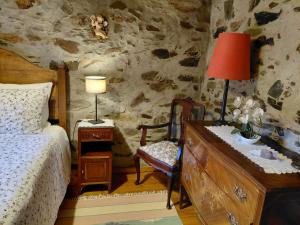 a bedroom with a bed and a table with a lamp at A Casa da Natália in Alvares