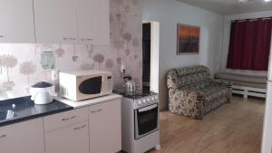 a kitchen with a microwave and a stove and a chair at Casa Amarela in Marcelino Ramos