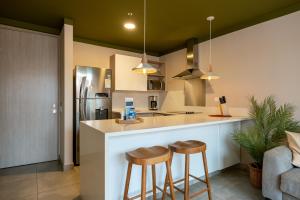 a kitchen with two bar stools and a refrigerator at Soul Lifestyle Hotel in Medellín