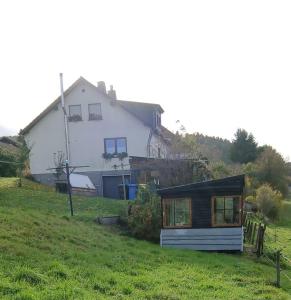 ヘレンタールにあるSunrise B&B Hellenthalの緑の畑の上に座る家