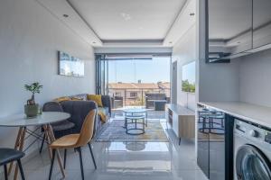 a kitchen and living room with a couch and a table at Greystone Serenity Apartment in Cape Town