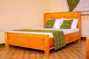 a wooden bed with two pillows on top of it at Materuni Home Stay in Uru East