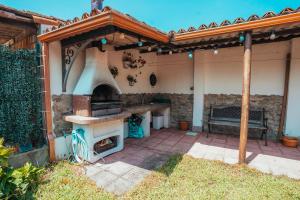 eine Außenküche mit Backofen und Sitzbank in der Unterkunft Villa Nora in Sanxenxo