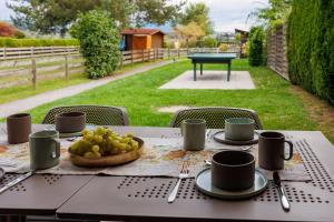 une table avec un bol de raisins et des tasses dessus dans l'établissement Apart of me Ferienhaus Faaker See, à Egg am Faaker See