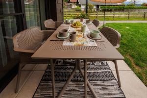 - une table en bois avec des chaises et de la nourriture sur la terrasse dans l'établissement Apart of me Ferienhaus Faaker See, à Egg am Faaker See 19 autres photos