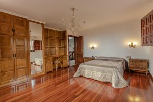 a large bedroom with a bed and wooden cabinets at Casona BRETEMA in Piñeiro +81 photos