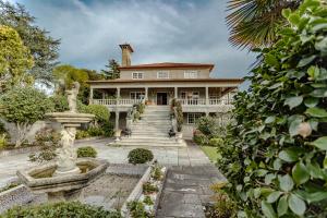 a large house with a fountain in front of it at Casona BRETEMA in Piñeiro