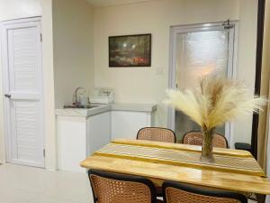 a dining room table with a vase of feathers on it at JC7 Twin Bed City Center Studio JEMS Bldg 3rd Floor IAN UNIT in Oaig Daya