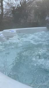 une baignoire remplie d'eau dans la cour dans l'établissement Villa Grande Est idéal famille Spa, à Plounéour-Trez