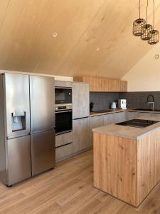 Il comprend une cuisine avec des appareils en acier inoxydable et du parquet. dans l'établissement Villa Grande Est idéal famille Spa, à Plounéour-Trez