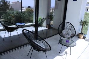 un gruppo di sedie e un tavolo su un balcone di LuxApart74 l Comfy & Minimal Stay in Ierapetra a Ierápetra
