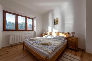 een slaapkamer met een groot bed in een kamer met ramen bij Fedákov Mlyn in Moldava nad Bodvou