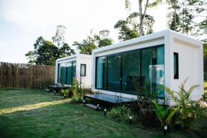 a tiny house with glass walls in a yard at Koh Kood AYA Homestay in Ko Kood