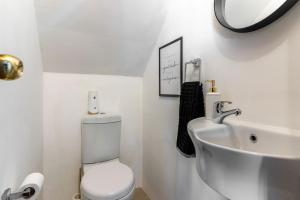 a white bathroom with a toilet and a sink at Modern Rustic Gem at the foot of Table Mountain in Cape Town +14 photos