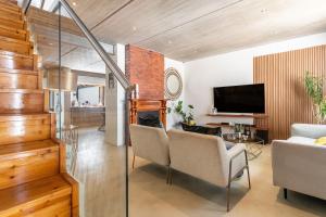 a living room with a fireplace and a tv at Modern Rustic Gem at the foot of Table Mountain in Cape Town