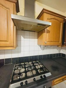 a stove top oven in a kitchen with wooden cabinets at Vintage Thistle House in Glasgow