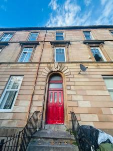 a red door on a building with a red door at Vintage Thistle House in Glasgow