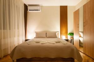 a bedroom with a large bed with two pillows at YaVi's Central Apartment in Veliko Tŭrnovo