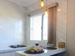 a kitchen with a table with a glass of wine at Apê Bella Vista Campos in Campos do Jordão +19 photos