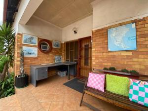 ein Bürobereich mit einer Bank und einem Schreibtisch in der Unterkunft Terrys Cozy Homestay in Germiston