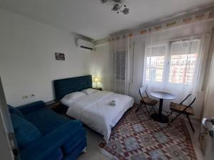 a bedroom with a bed and a blue couch at Isabel Rooms in Tirana