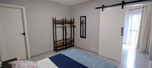 a room with white walls and a blue rug at Apê Bella Vista Campos in Campos do Jordão