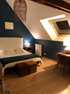 a bedroom with a bed with a blue wall at Chambre d'hôte - Verdure en ville in Les Ponts-de-Cé
