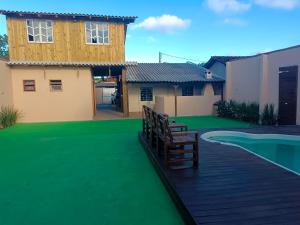 a house with a deck with a green lawn at Sonho Meu in Itapoa
