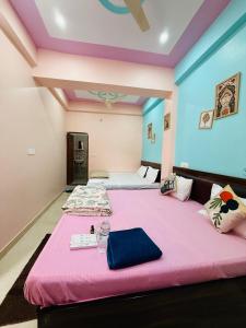 AyodhyaにあるATULYAM STAYs PREMIUMのベッドが2つある部屋に大きなピンクのベッドがある