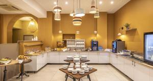 a large kitchen with white cabinets and a counter at Best Western Plus Sanary in Sanary-sur-Mer