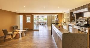 una cocina grande con encimera y sillas. en Best Western Plus Sanary, en Sanary-sur-Mer