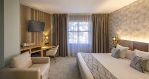 una habitación de hotel con una cama y un escritorio en Best Western Plus Sanary, en Sanary-sur-Mer