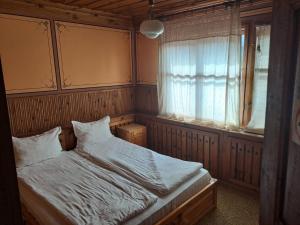 a small bedroom with a bed and a window at Карагьозовата Къща - цяла къща - 6 големи спални, 6 бани и отделна механа in Koprivshtitsa
