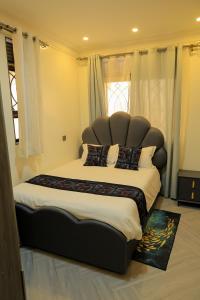 a large bed with a large headboard in a bedroom at Luxury Gem in Nsambya 1km from American Embassy in Kampala