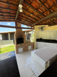 une cuisine avec une cheminée en briques et un poêle dans l'établissement Chácara Rbs, à Sobral